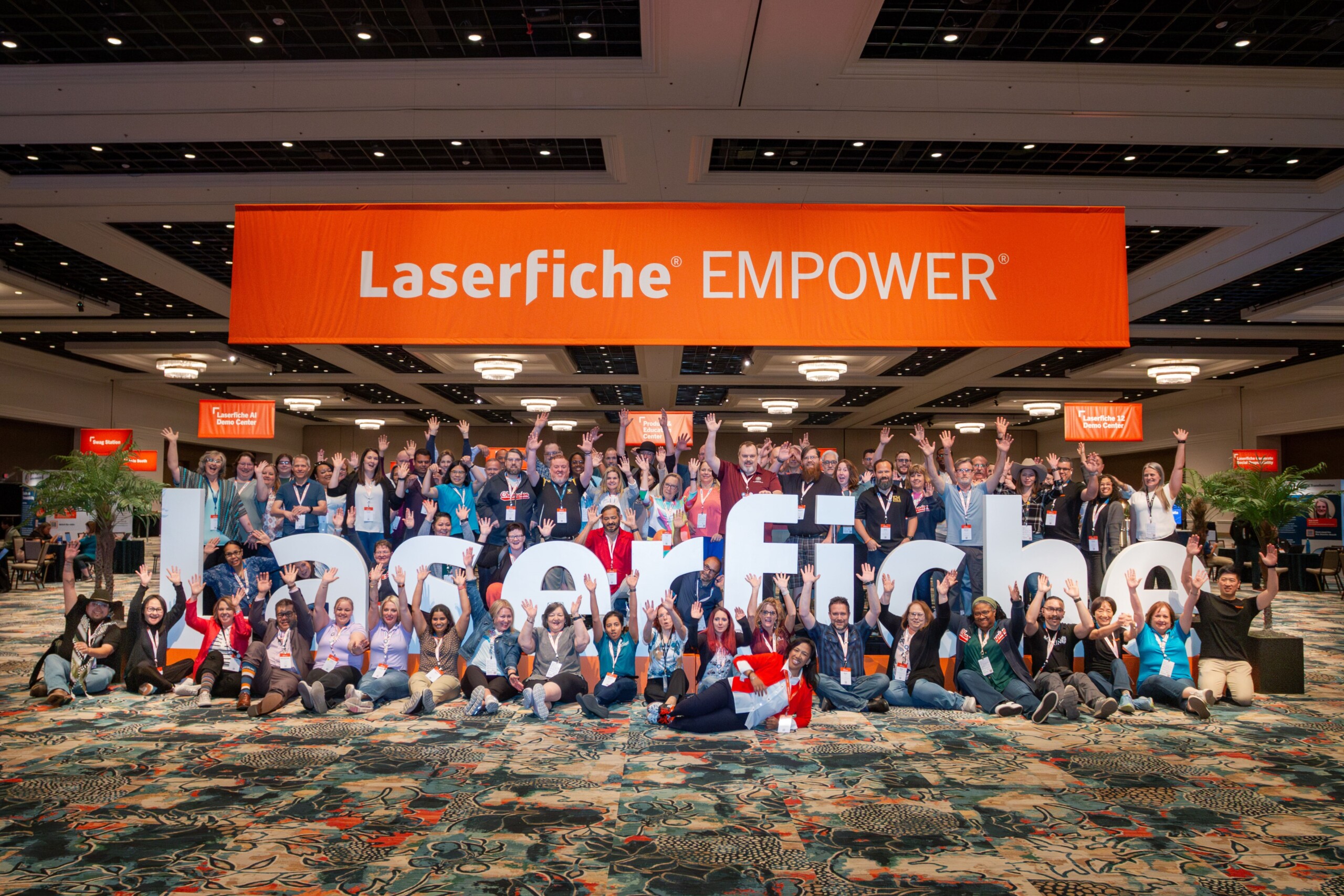 Laserfiche customers around a Laserfiche sign at the Empower conference.