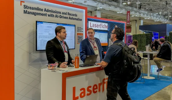Laserfiche employees at Educause discussing opportunities for workflow automation with a visitor