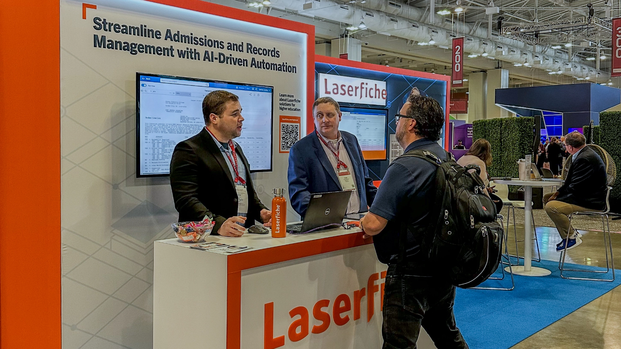 Laserfiche employees at Educause discussing opportunities for workflow automation with a visitor